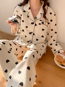 Detail of cream ribbed pajamas with black heart prints and contrast piping on the collar