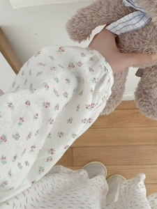 Close-up of floral cotton nightgown featuring elastic cuffs and red flower patterns