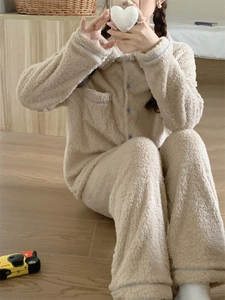 Detail showing plush coral fleece texture and contrast blue buttons on the beige loungewear