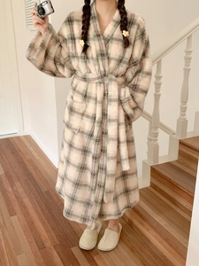 Detail of plush checkered bathrobe showing soft coral fleece texture and waist tie
