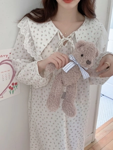 Detail of elegant cotton nightdress featuring floral pattern, lace collar and ribbon bow