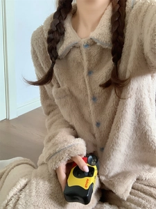 Detailed close-up of soft beige double-sided plush winter pajamas with blue buttons