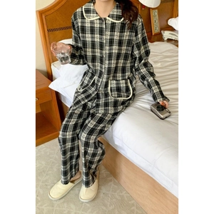 Classic black and white checkered long-sleeved pajamas set with white piping on a bed
