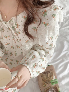 Detail of floral cotton nightgown featuring a large lace collar and delicate bow tie