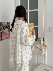 Detail of floral cotton pajama set featuring doll collar and ruffle trim in a cozy room