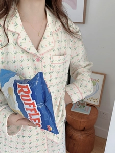 Detail of cream tulip pajamas showing quilted cotton fabric texture and pink piping finish