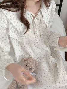 Close-up of floral cotton nightgown featuring a lace Peter Pan collar and bow tie detail