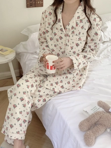 Cozy floral pajama set featuring long-sleeve button-down top and matching pants in a bedroom
