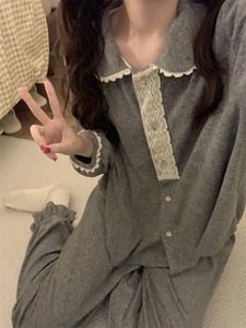 Détail d'un pyjama en polaire grise avec col en dentelle blanche et boutons