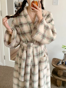 Close-up of thick flannel plaid bathrobe showing soft texture and cozy waist belt
