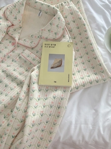 Detailed close-up of quilted floral pajamas with pink tulip patterns on white fabric