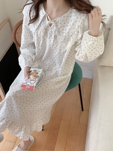 Close-up of lace collar and floral patterns on white cotton long sleeve nightgown