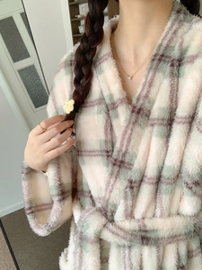 Detail of soft plush plaid bathrobe with thick flannel texture and belted V-neck design