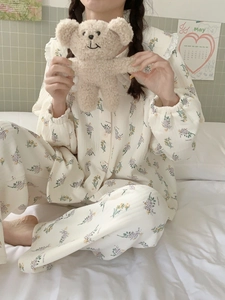 Detail of floral cotton pajamas set with ruffled doll collar and warm quilted texture