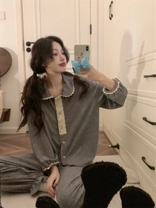 Détail de pyjama en polaire grise avec bordure en dentelle et boutons dans un intérieur