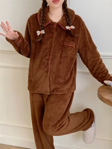 Close-up of brown plush pajamas with pink piping details and red buttons on the pocket