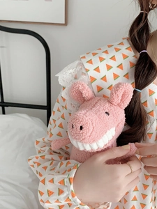 Gros plan sur un cochon en peluche rose avec dents blanches et texture en laine bouclée