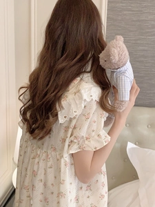 Dettaglio di camicia da notte a fiori con colletto in pizzo e polsini a balze sul retro