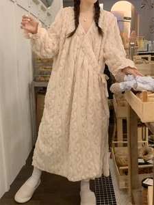 Détail d'un peignoir en peluche crème avec maille torsadée et ceinture en satin