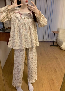 Dettaglio del colletto in pizzo con fiocchi rosa sul pigiama da donna con stampa cigno