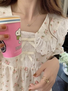 Dettagli camicia da notte a fiori con volant in pizzo e fiocchi in seta sul colletto