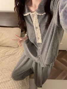 Détail d'un pyjama en flanelle grise avec bordure en dentelle blanche et boutons ronds