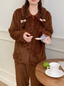 Detail of warm brown coral fleece pajamas with pink contrast piping and round buttons