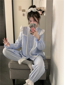 Detail of light blue pajama set with striped cotton texture and white lace embroidery