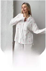 Detail of white women's pajama set featuring red heart prints and breathable seersucker fabric