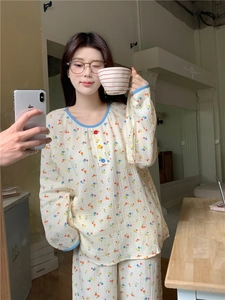 Détail du haut de pyjama à fleurs avec col à bordure bleue et boutons décoratifs colorés