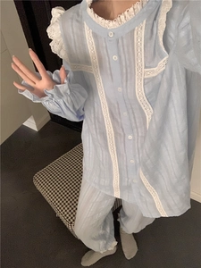 Detail of light blue pajama set featuring elegant white lace edges and ruffled cuffs