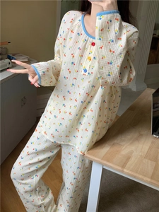 Détail du pyjama à fleurs à manches longues avec bordure bleue et boutons colorés