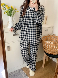Detail des karierten Pyjama-Sets mit Spitzenkragen und gerüschten Saumkanten