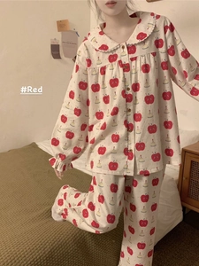 Detail of red apple print and ruffled cuffs on loose white cotton pajama set