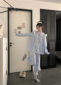 Detail of light blue striped pajamas with delicate white lace trim and ruffled edges