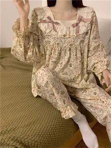 Dettaglio del pigiama floreale con scollo quadrato in pizzo e fiocchi rosa decorativi