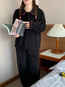 Detail of warm black fleece pajama set featuring contrast pink piping and soft texture
