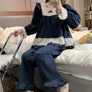 Detail of navy blue pajamas featuring white lace square neck and bow decorations