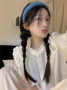 Close-up of a blue velvet headband worn by a model with a white lace pajama shirt