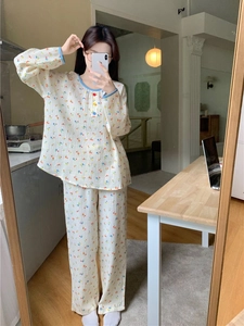 Détail d'un pyjama fleuri à manches longues avec boutons colorés et liseré bleu élégant