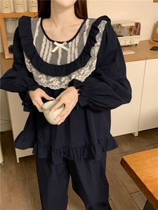 Close-up of navy blue pajama top with white lace ruffle collar and bow detail