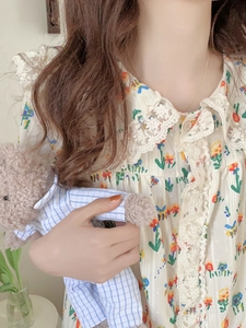 Détail d'un pyjama à fleurs avec dentelle délicate et col Claudine de style poupée
