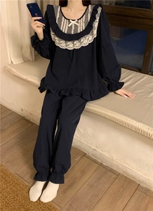 Detail of navy blue pajama set with white lace trim and bowknot on the neckline