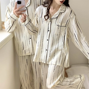 Detail of couple's striped cotton pajamas set featuring a notched collar and chest pocket