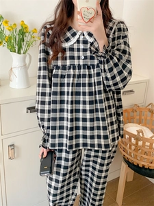 Detail eines karierten Langarm-Pyjama-Sets mit Spitzenkragen und Oberteil zum Knöpfen
