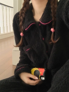 Detail of black flannel pajamas with pink piping trim and button-down collar