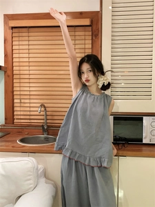 Detail of teal cotton pajama set featuring sleeveless top with double ruffled hem and red trim