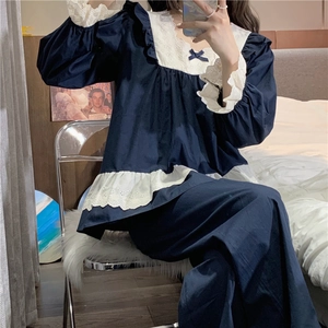 Detail of navy blue pajama set with square neck, white lace trim and sweet blue bow decoration