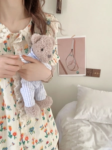 Détail de pyjama floral avec bordure en dentelle et ours en peluche en tenue à carreaux