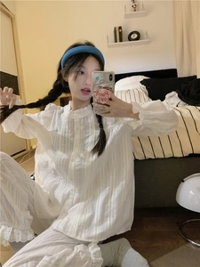 Close-up of white lace trim on vertical striped fabric of a long sleeve pajama set